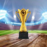 Trophy(CS-036) gold trophy on wooden base with blurred stadium background for recognition of achievement.
